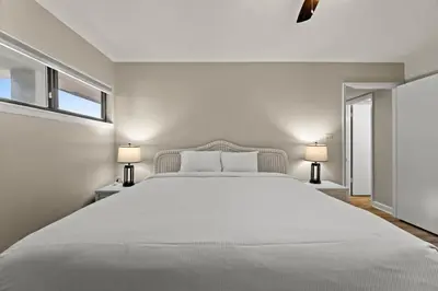 a white bedroom with a large bed and two lamps at Aquavista 804E in Panama City Beach