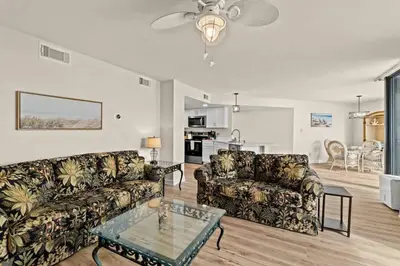 a living room with two couches and a table at Aquavista 804E in Panama City Beach