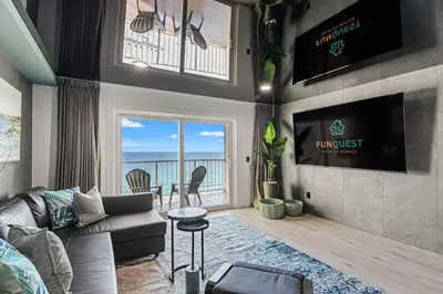 a living room with a couch and a tv at The Summit 1305 in Panama City Beach