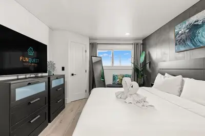 a bedroom with a large white bed with a television at The Summit 1305 in Panama City Beach