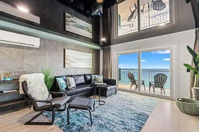 a living room with a couch and a table and chairs at The Summit 1305 in Panama City Beach