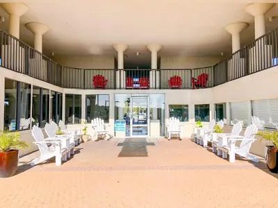 a lobby with white chairs and a balcony at Top Of The Gulf 704 in Panama City Beach
