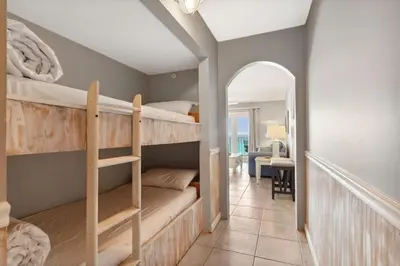 a room with two bunk beds and a hallway at The Summit 817 in Panama City Beach