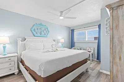 a bedroom with a white bed and a window at The Summit 712 in Panama City Beach