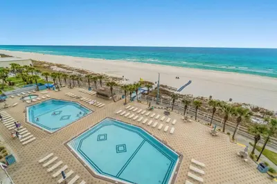 an overhead view of a beach with two swimming pools at The Summit 712 in Panama City Beach