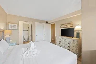 a bedroom with a white bed and a television at The Summit 307 in Panama City Beach