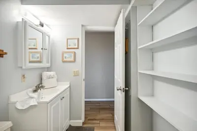 a white bathroom with a sink and a mirror at The Summit 307 in Panama City Beach