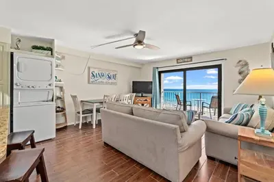a living room with couches and a dining room with the ocean at The Summit 731 in Panama City Beach
