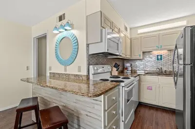a kitchen with white cabinets and a stove top oven at The Summit 731 in Panama City Beach