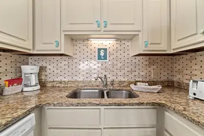 a kitchen with white cabinets and a sink at The Summit 731 in Panama City Beach