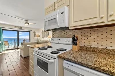 a kitchen with white appliances and a living room at The Summit 731 in Panama City Beach