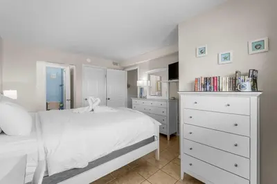 a bedroom with a white bed and a white dresser at The Summit 1123 in Panama City Beach