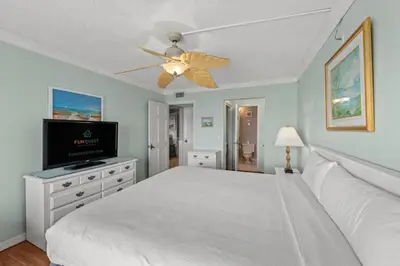 a bedroom with a white bed and a ceiling fan at The Summit 1503 in Panama City Beach