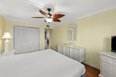 a bedroom with a white bed and a ceiling fan at The Summit 1503 in Panama City Beach