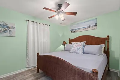 a bedroom with a bed with a ceiling fan at Paradise Found in Panama City Beach