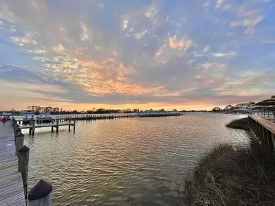 a dock on a body of water at sunset at Paradise Found in Panama City Beach