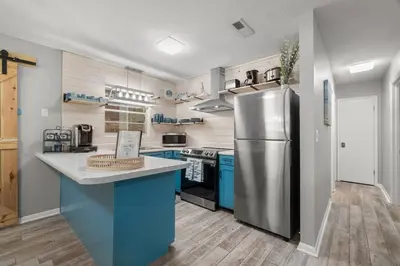 a kitchen with blue cabinets and a stainless steel refrigerator at Paradise Found in Panama City Beach