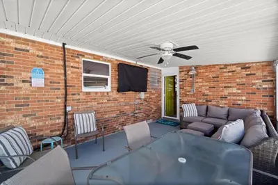 a patio with a couch and a ceiling fan at Paradise Found in Panama City Beach
