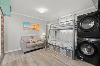 a living room with a bunk bed and a chair at Paradise Found in Panama City Beach