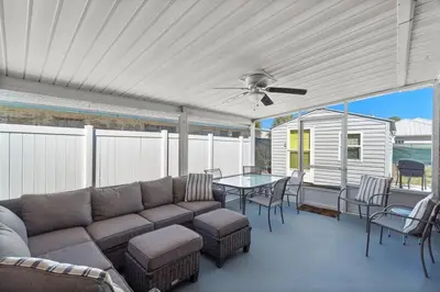 a patio with a couch and a table with chairs at Paradise Found in Panama City Beach