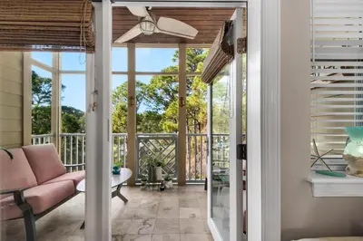 a living room with a pink couch and a balcony at 30A-SEA For Yourself - Seagrove Highlands in Santa Rosa Beach