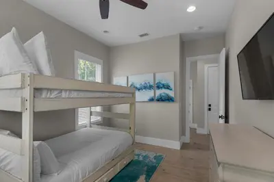 a bedroom with two bunk beds and a flat screen tv at Lifestyles & Dreams in Santa Rosa Beach