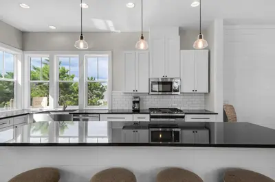 a kitchen with white cabinets and a black counter top at Lifestyles & Dreams in Santa Rosa Beach