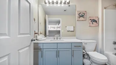 a bathroom with a sink and a toilet and a mirror at Deep Blue at Laketown Wharf #214 by Nautical Properties in Panama City Beach