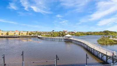 a dock on a river with a town in the background at Deep Blue at Laketown Wharf #214 by Nautical Properties in Panama City Beach