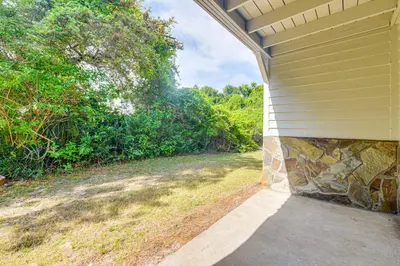 a house with a stone wall on the side of it at Santa Rosa Beach Townhome Patio, Walk to Beach! in Santa Rosa Beach