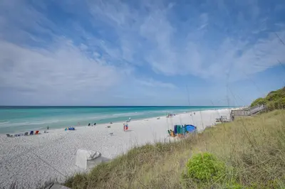 a group of people on a beach near the ocean at Santa Rosa Beach Townhome Patio, Walk to Beach! in Santa Rosa Beach