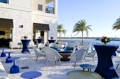 a patio with chairs and tables and a body of water at Hotel Indigo - Panama City Marina by IHG in Panama City