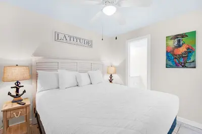 a bedroom with a white bed and a ceiling fan at Sunbird 709W Beach Life in Panama City Beach