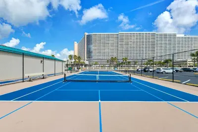 a tennis court in front of a hotel at Sunbird 709W Beach Life in Panama City Beach
