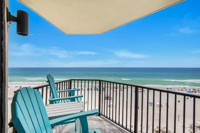 a balcony with two chairs and the beach at Sunbird 709W Beach Life in Panama City Beach