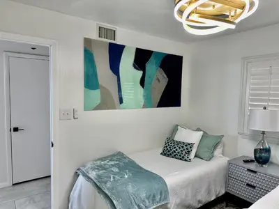 a bedroom with a bed and a painting on the wall at One Seagrove Place #1308 - 