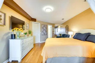 a bedroom with a large bed and yellow walls at Charming Panama City Studio with Community Pool! in Panama City Beach