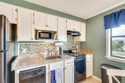 a kitchen with white cabinets and a sink and a microwave at Charming Panama City Studio with Community Pool! in Panama City Beach