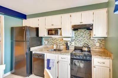a kitchen with white cabinets and a stainless steel refrigerator at Charming Panama City Studio with Community Pool! in Panama City Beach