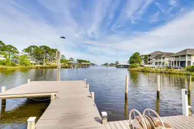 a dock on a body of water with houses at Charming Panama City Studio with Community Pool! in Panama City Beach