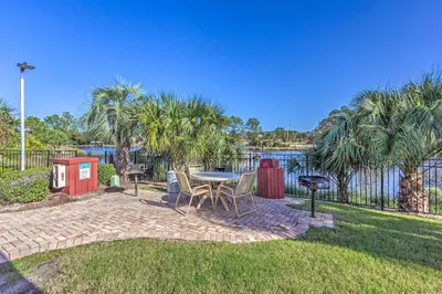 a patio with a table and chairs in the grass at Charming Panama City Studio with Community Pool! in Panama City Beach