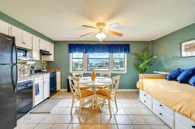 a kitchen and dining room with a table and a bed at Charming Panama City Studio with Community Pool! in Panama City Beach