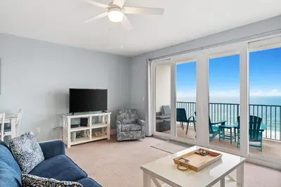 a living room with a couch and a tv and a balcony at A Shore Thing at Laketown Wharf #1904 by Nautical Properties in Panama City Beach