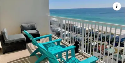 a balcony with two blue chairs and the ocean at A Shore Thing at Laketown Wharf #1904 by Nautical Properties in Panama City Beach