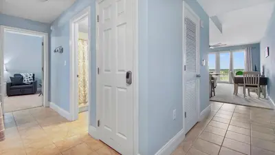 a hallway with a door leading to a living room at Shell Yeah at Laketown Wharf #730 by Nautical Properties in Panama City Beach