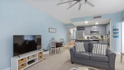 a living room with a couch and a large tv at Shell Yeah at Laketown Wharf #730 by Nautical Properties in Panama City Beach
