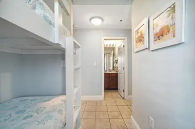 a bedroom with a bunk bed and a staircase at Keep It Beachy at Laketown Wharf #611 by Nautical Properties Vacation Rentals in Panama City Beach