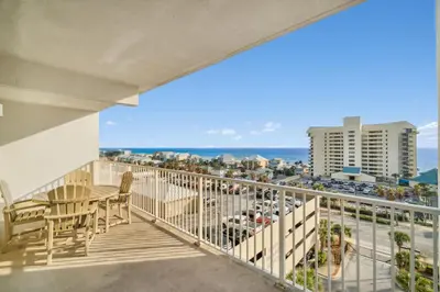 a balcony with a table and chairs and a view of a city at Keep It Beachy at Laketown Wharf #611 by Nautical Properties Vacation Rentals in Panama City Beach