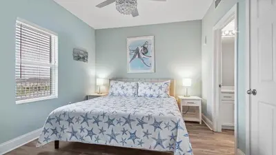 a bedroom with a bed and two lamps and a window at Beach Dream Believer at Laketown Wharf #518 by Nautical Properties in Panama City Beach
