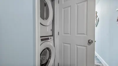 a washing machine sitting next to a white door at Beach Dream Believer at Laketown Wharf #518 by Nautical Properties in Panama City Beach